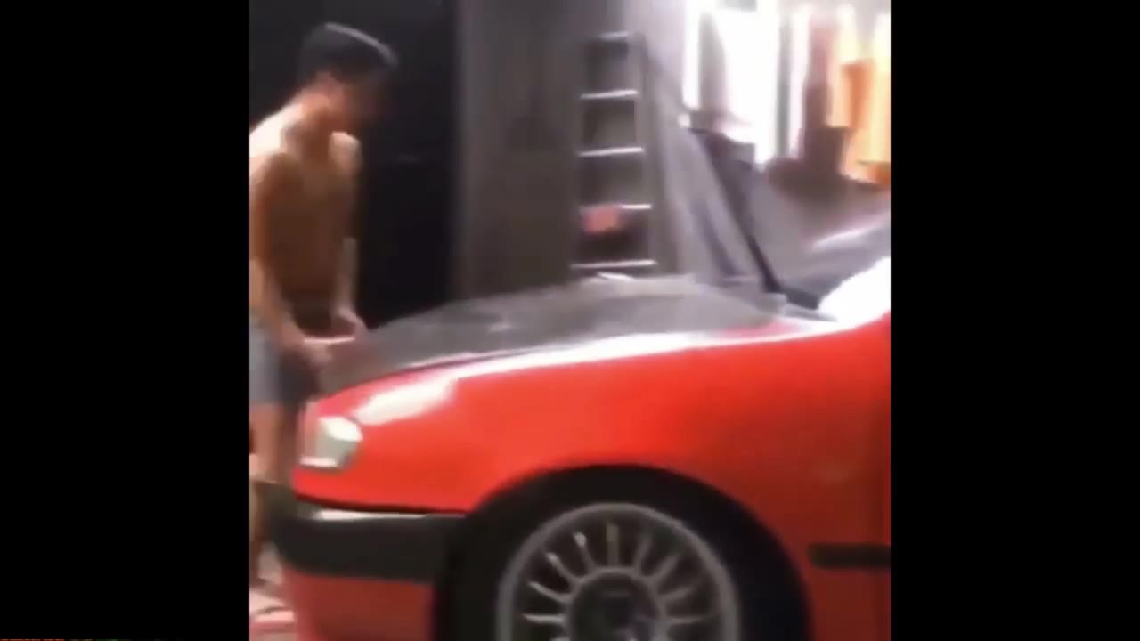 Man Inspects Red Car